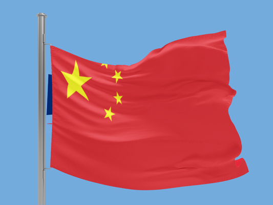 Flag of China waving against a blue sky